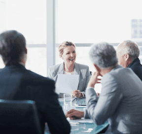 Porada byznysmenů ve formálním prostředí se ženou uprostřed