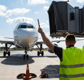 Operátér na letišti dává signál letadlu k přistání